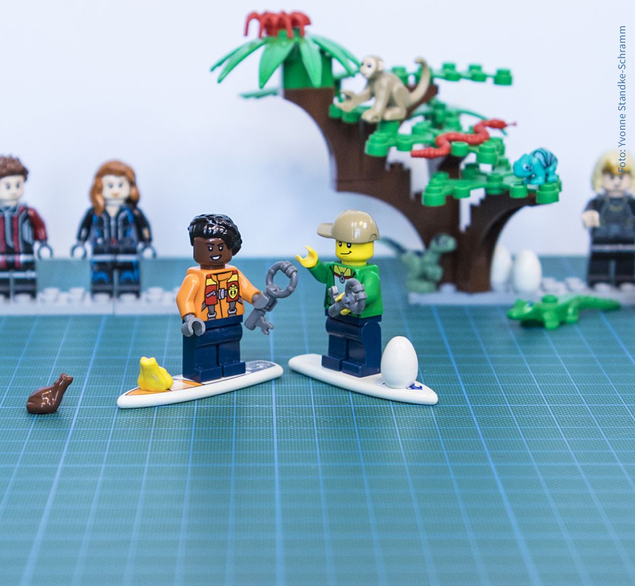 Surfende Kinder vor Superheld:innen in Lego