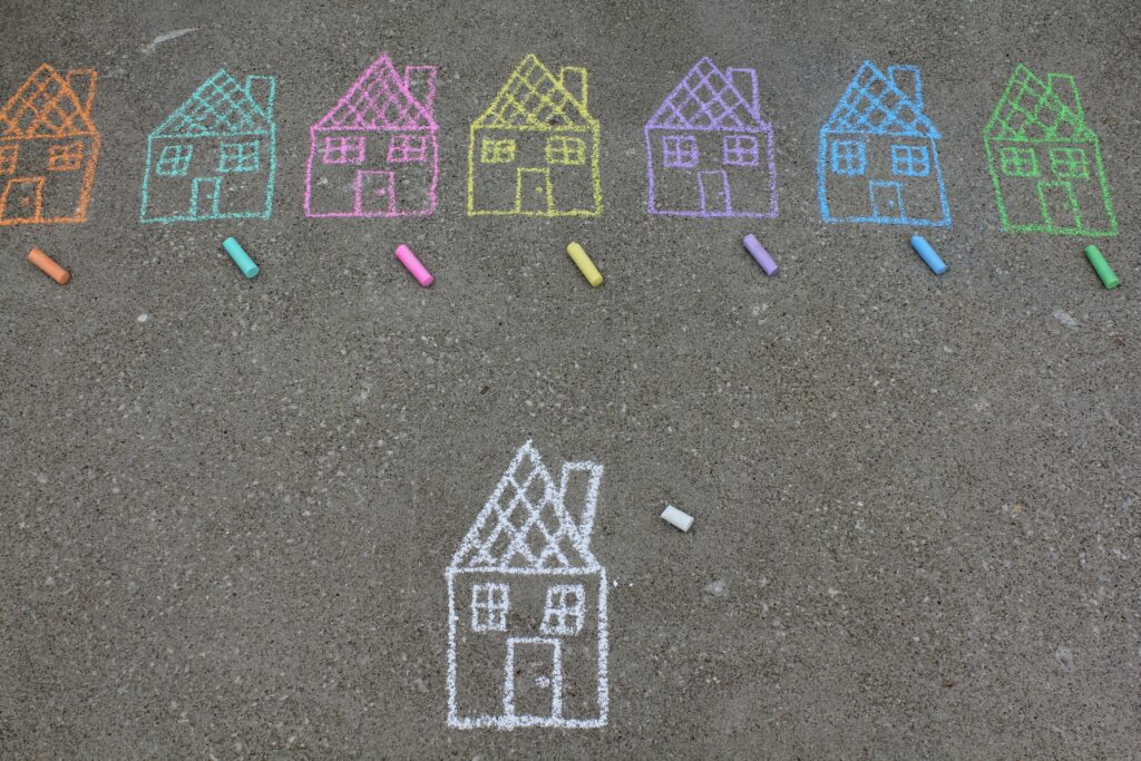 Bunte Häuser mit Kreide auf dem Boden gemalt.