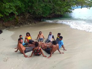 Group of young people sitting on the beach.