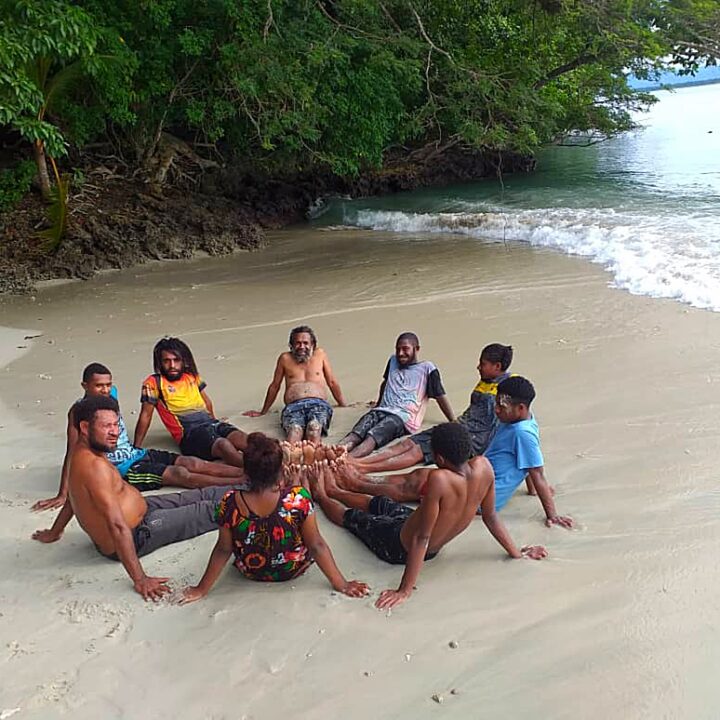 Group of young people sitting on the beach.