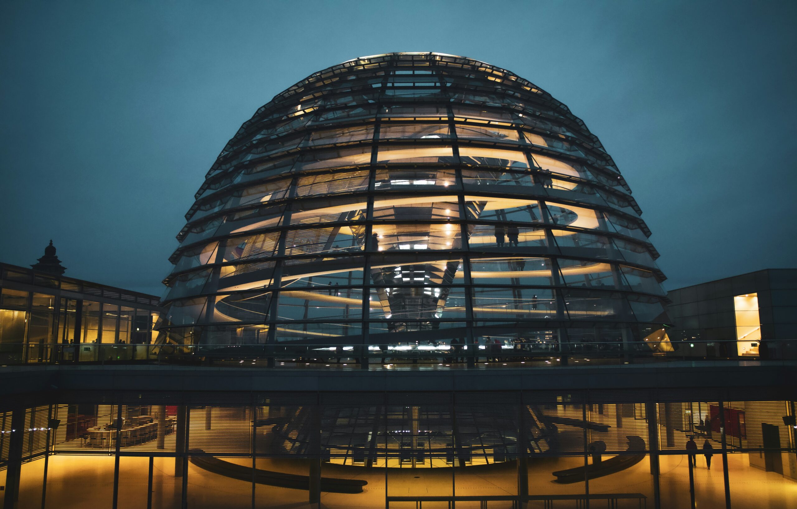 Von innen erleuchtete Kuppel des Reichstagsgebäudes in Berlin am Abend.