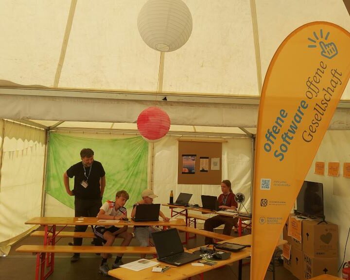 Drei Jugendliche und eine anleitende Person beim Workshop MitmachMap beim Konficamp 2025 im Projekt "Offene Software - offene Gesellschaft"
